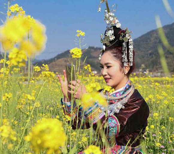 トン族の村に春来たる、花と戯むる村の女性たち