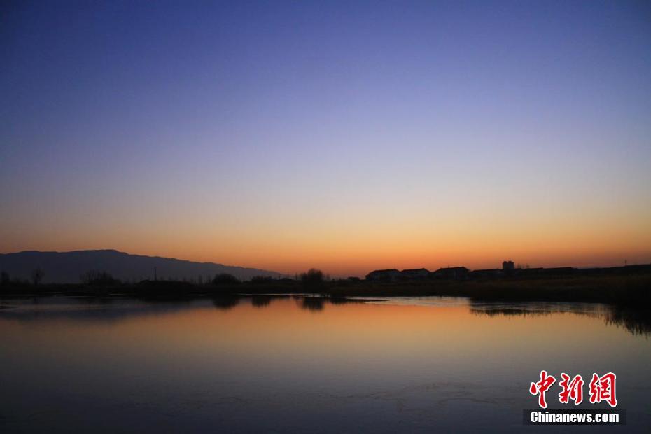 初冬、夜明けの太陽に赤く染まるゴビ湿地　甘粛省