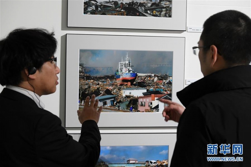 3月10日、「気仙沼市東日本大震災遺構・伝承館」で写真の説明をするスタッフ(撮影・華義)。