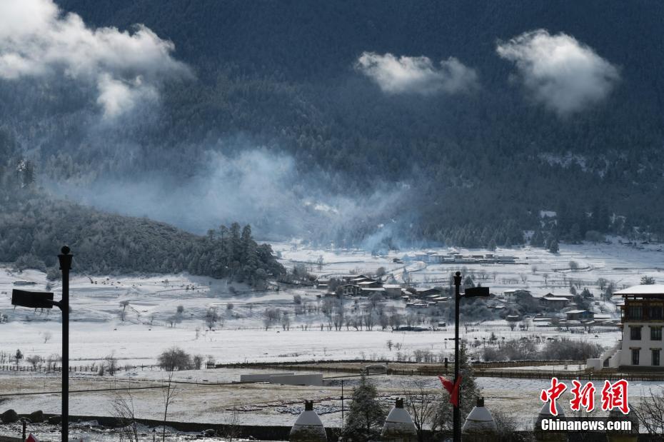 3月22日、夜に雪が降り、村の林や牧草地が白く染まった観光村。山も雪化粧の絶景に（撮影・楊程晨）。