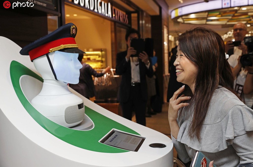 案内ロボットの「セミ」に駅構内などの案内をしてもらう乗客（写真著作権は東方ICが所有のため転載禁止）。