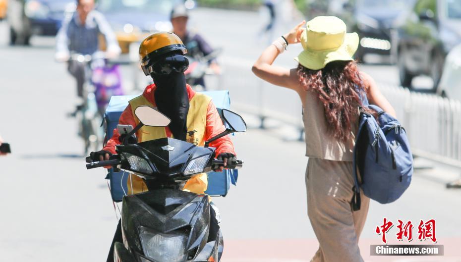 5月23日、高温・快晴天気のもとで配達するフードデリバリー担当の男性（撮影・賈天勇）