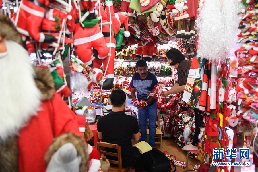 6月26日、義烏国際商貿城のある店でクリスマスグッズを仕入れるインド人バイヤー（写真中央、撮影・黄宗治）。