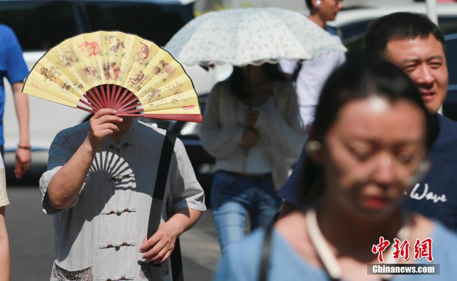 様々な日焼け対策をして外出する市民（撮影・賈天勇）。  