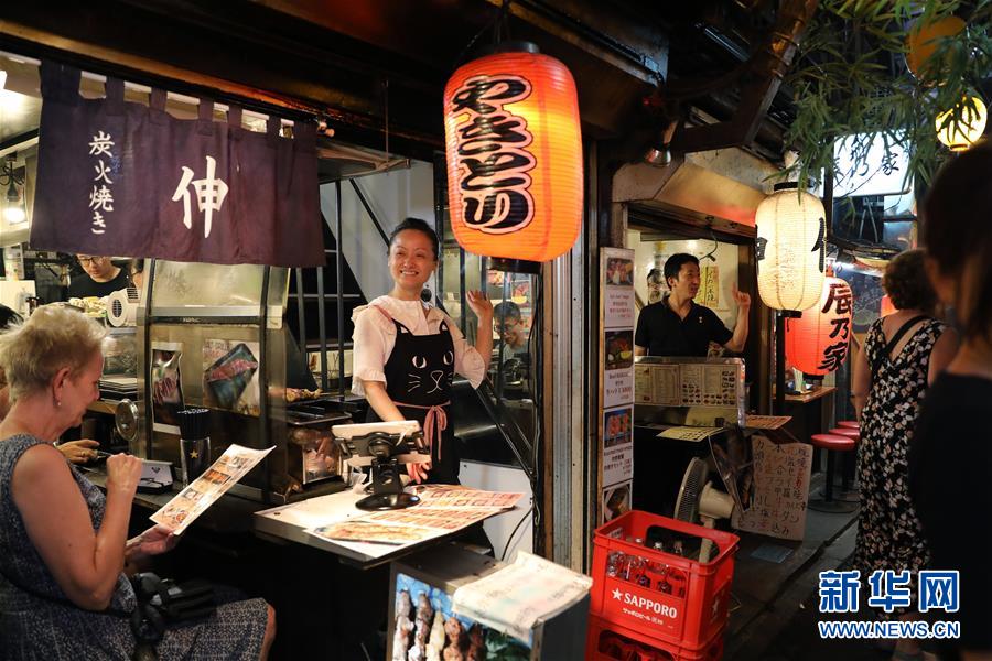 東京の新宿で13日夜、客に声をかける店主（撮影・杜瀟逸）。