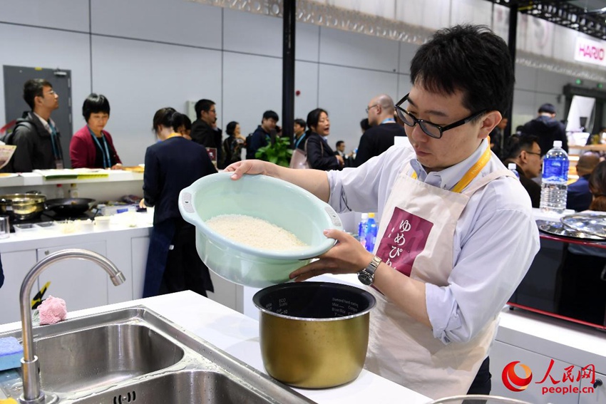 研いだ米を炊飯器に移す石山さん。