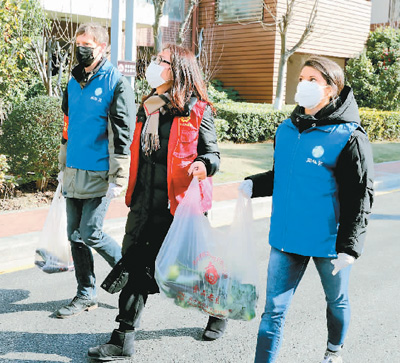 住民のために野菜や食料品を配達する米国人の蘇貝◆さん（写真右）と夫の蘇傑夫さん（写真左、撮影・華雪根）。