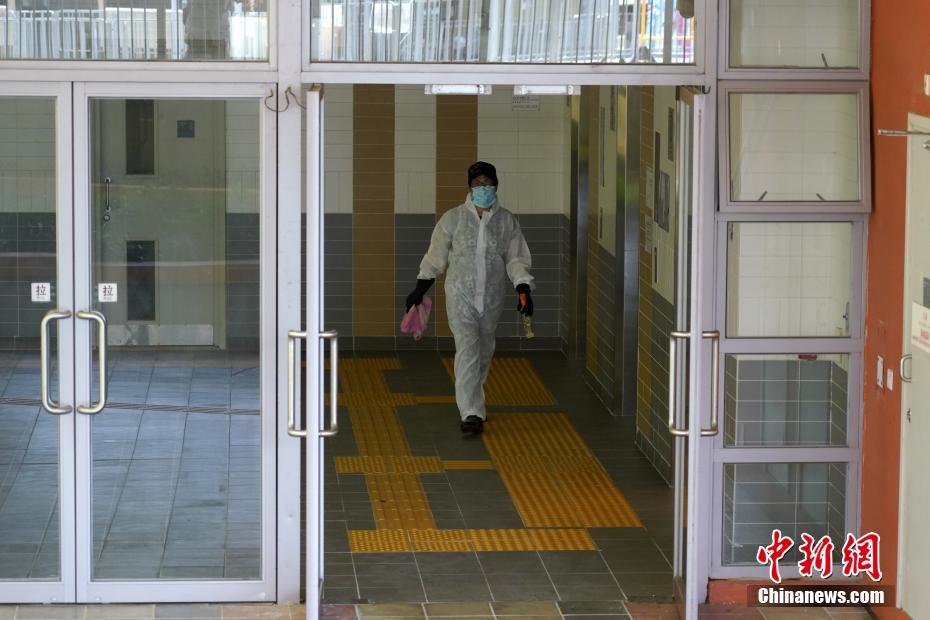 7月11日、防護服を着用して香港地区沙田にある水泉澳邨明泉楼の内部を消毒する作業員（撮影・張煒）。