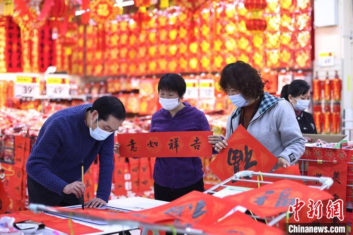 買い物客に無料で「春聯」や「福」の字を書く書道家（撮影・泱波）。