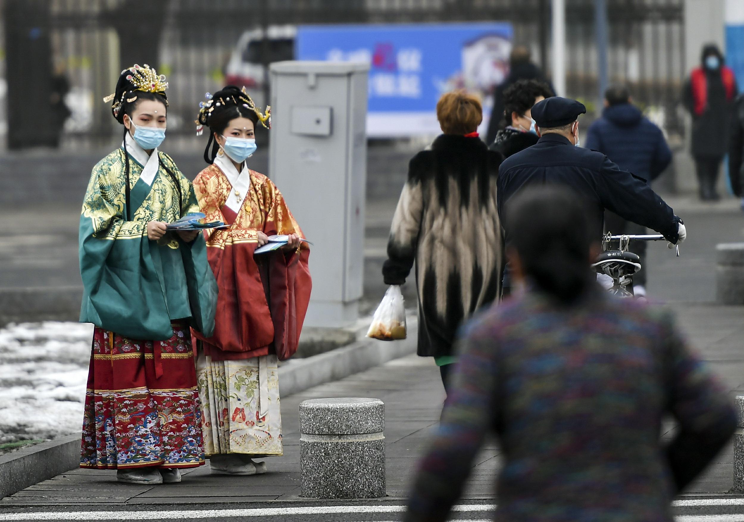 3月10日、新疆ウルムチ市ハイテク区（新市区）の北京路で、交通ルールやマナーを守った外出を通行者に呼びかける、漢服姿のボランティア（写真著作権はCFP視覚中国が所有のため転載禁止）。