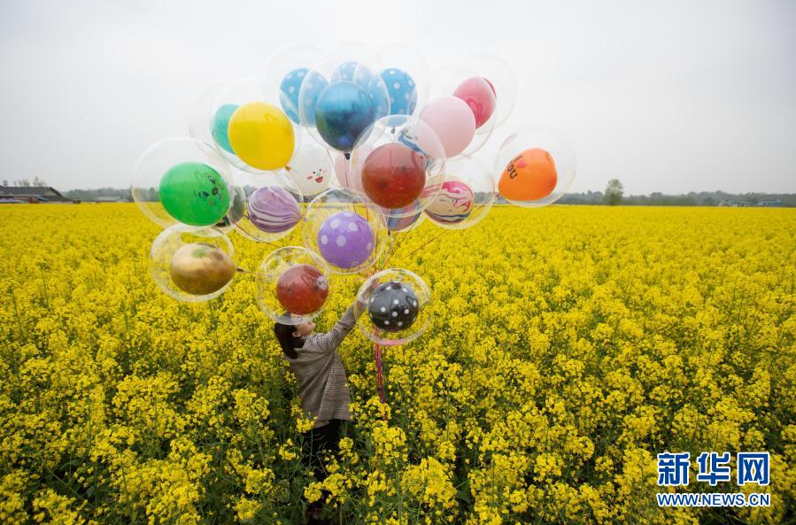 3月14日、四川省綿陽市安州区秀水鎮竜泉村の菜の花畑で記念写真を撮影する観光客（撮影・江宏景）。