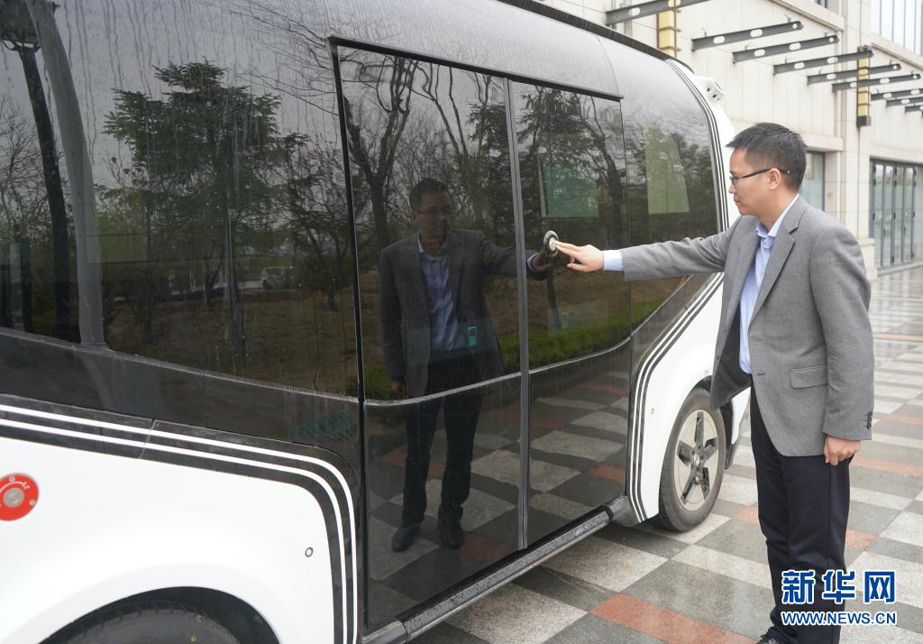 3月26日、雄安智絵未来科技園で、センサーにタッチして無人運転列車の乗降ドアを開ける、雄安デジタル交通実験室の任大凱さん（撮影・金皓原）。