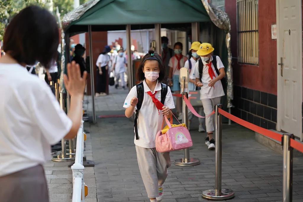 9月1日、新学期初日を迎えた北京十一学校豊台小学校の校門で児童を迎える教員（撮影・翁奇羽）。