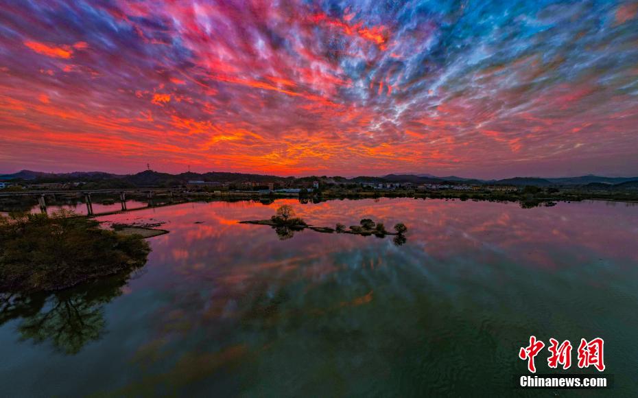 河川や村落とともに見事な自然景観を作りあげた色彩鮮やかな夕焼け雲（撮影・趙春亮）。