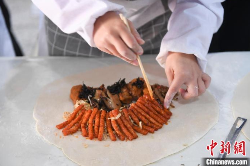 「辣条」とひき肉の具を餃子の皮で包む従業員（撮影・楊華峰）。