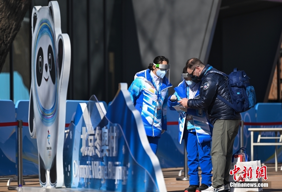 北京冬季五輪選手村のゲストにガイダンスを行うボランティア（写真左、1月29日撮影・何蓬磊）。