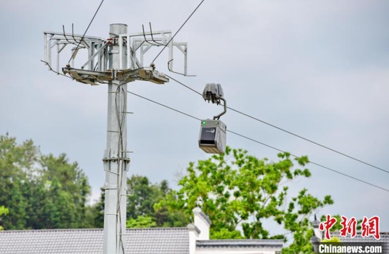 4月14日、江西省贛州市安遠県鶴子鎮陽佳村で、農産物を積載したスマート物流配送快速ラインのロープウェイで移動する「往来ロボット」（撮影・朱海鵬）。