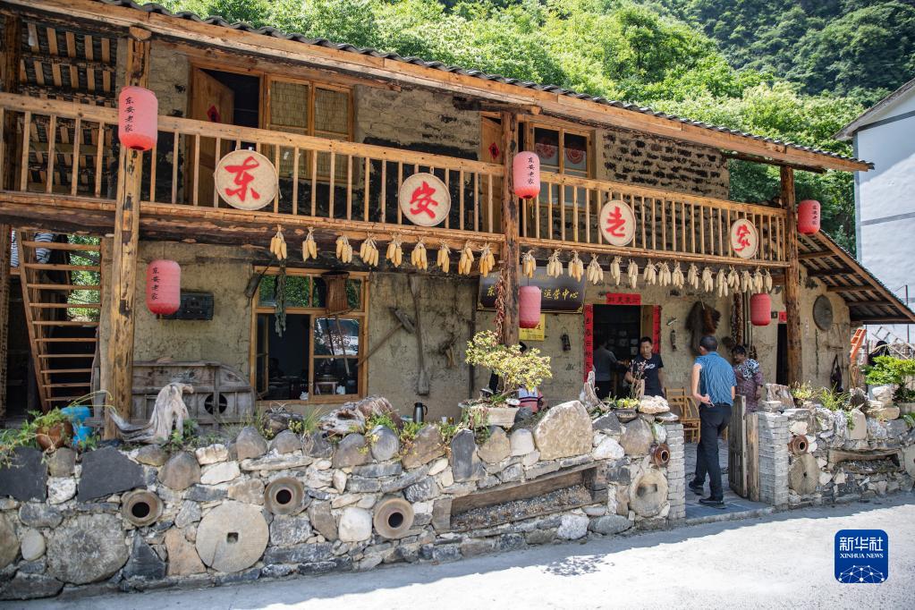 重慶市城口県東安鎮黄金村で空き家になっていたレンガ造りの民家を改装した民宿を訪れた観光客（6月15日撮影・黄偉）。