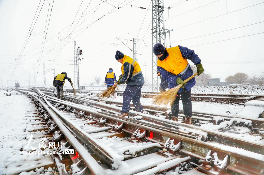 鉄道輸送の安全性と円滑性を確保するため、分岐器の除雪作業を行う中国鉄路瀋陽局集団公司の職員（11月12日撮影・李季春/写真著作権は人民図片が所有のため転載禁止）。