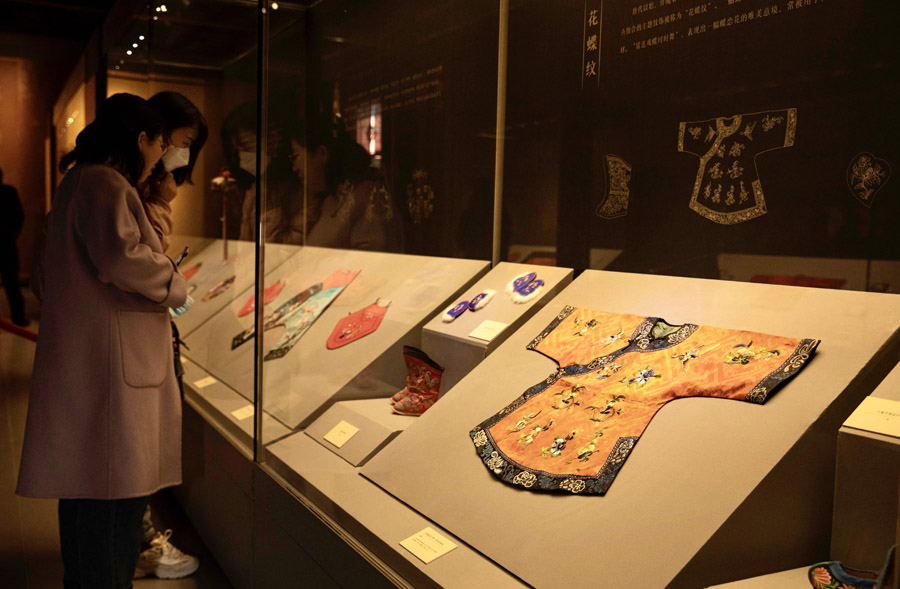 赤い生地に藍色の縁取りが施された「平繍三多紋」の女児の服（写真右）。