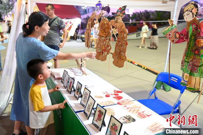 長沙の影絵を鑑賞する子供を連れた女性（撮影・楊華峰）。