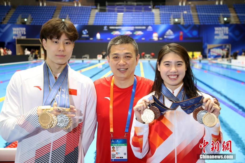 試合後、監督と記念写真を撮影する張雨霏選手（写真右）と覃海洋選手（写真左、撮影・湯彦俊）