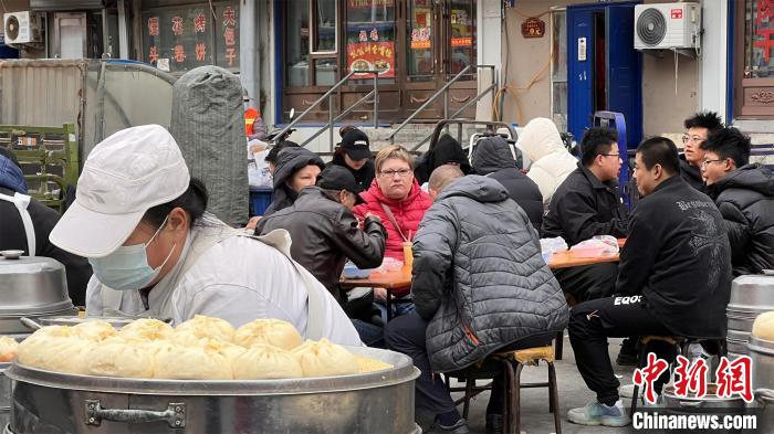 黒河市の朝市でできたての包子を味わうロシア人観光客（撮影・孫旭）。