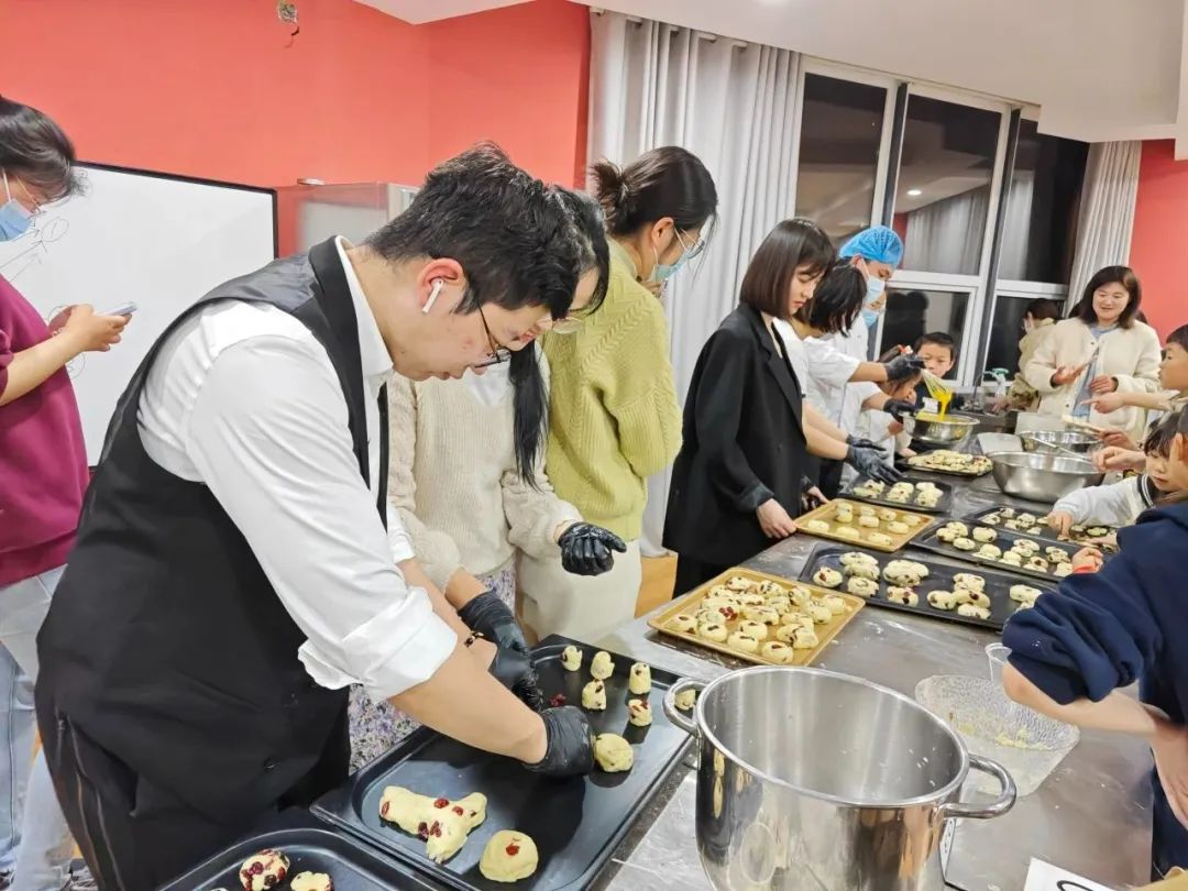 江蘇省徐州新沂市の焼き菓子教室で、先生に教わりながらクランベリースコーンを焼く受講生たち。